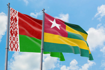 Togo and Belarus flags waving in the wind against white cloudy blue sky together. Diplomacy concept, international relations.