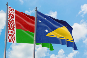 Tokelau and Belarus flags waving in the wind against white cloudy blue sky together. Diplomacy concept, international relations.