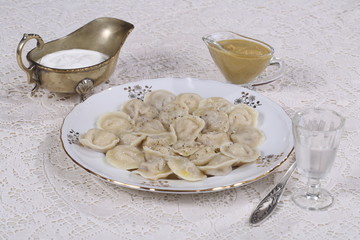 Hot Siberian dumplings with greens on a white plate
