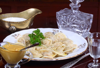 Hot Siberian dumplings with greens on a white plate