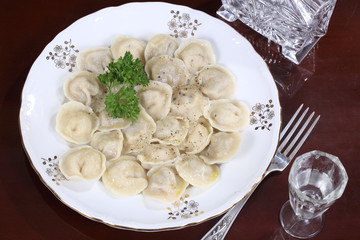 Dumplings with sour cream on a wooden table