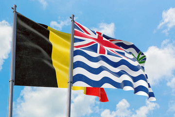 British Indian Ocean Territory and Belgium flags waving in the wind against white cloudy blue sky together. Diplomacy concept, international relations.