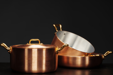 Set of copper cookware over dark background