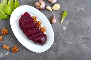 Slices of boiled beets on a white plate. Source of energy. Dietary healthy vegetable. Top view.