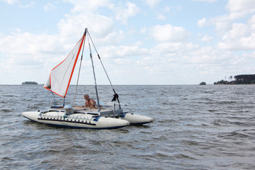 Man lowering catamaran into river, Ob Reservoir, Novosibirsk, Russia
