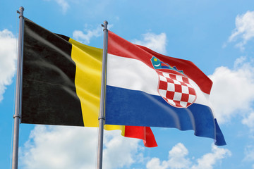 Croatia and Belgium flags waving in the wind against white cloudy blue sky together. Diplomacy concept, international relations.