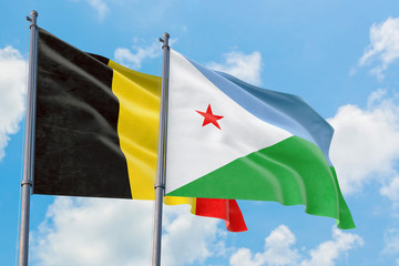 Djibouti and Belgium flags waving in the wind against white cloudy blue sky together. Diplomacy concept, international relations.