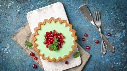 Delicious mint tart with fresh cranberry and vintage silverware