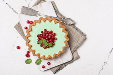 Delicious mint tart with fresh cranberry and vintage silver .cake server