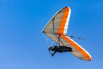 Hang Glider flying in the sky on a sunny day. Recreational activities during the summer holidays....