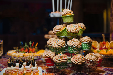 Freshly made cupcakes stand on a stand.