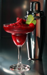 Bright exotic cocktail in a glass on a black background.