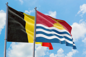 Kiribati and Belgium flags waving in the wind against white cloudy blue sky together. Diplomacy concept, international relations.