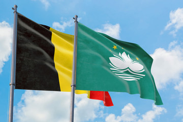 Macao and Belgium flags waving in the wind against white cloudy blue sky together. Diplomacy concept, international relations.