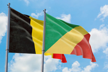 Republic Of The Congo and Belgium flags waving in the wind against white cloudy blue sky together. Diplomacy concept, international relations.