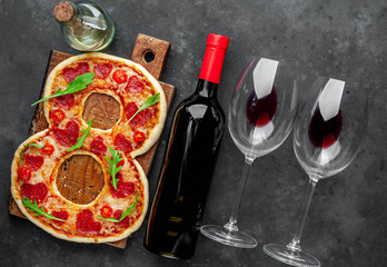 Dinner for two. Pizza in the form of 8, a bottle of wine and glasses for International Women's Day on March 8 on a stone background. March 8 celebration concept.