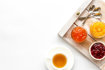 Fruit jam near tea on white kitchen desk frame copy space