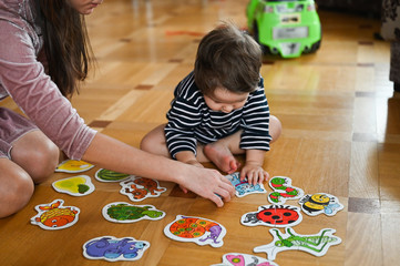 Child development at home. Baby boy and insects. Mom and baby are studying nature. Babysitter and baby