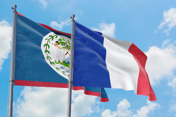 France and Belize flags waving in the wind against white cloudy blue sky together. Diplomacy concept, international relations.