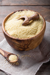 Raw Couscous in a wooden bowl on the table