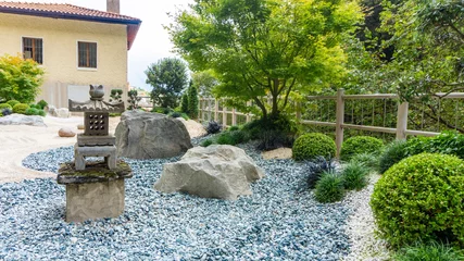 Fotobehang Bonsai Charming Japanese-style garden with traditional attributes: Oki-gata lantern, gravel paths, boxwood trimmed bushes, maple trees. Landscaping photo of japanese garden.  © nieriss