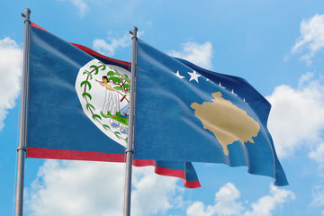 Kosovo and Belize flags waving in the wind against white cloudy blue sky together. Diplomacy concept, international relations.