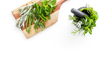 Make seasoning and condiments. Herbs in mortar on white background top-down copy space