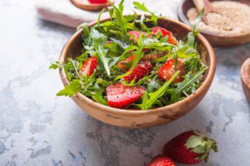 Diet menu concept. Summer Healthy salad with quinoa, strawberry, and arugula. Top view flat lay background on light stone table with copy space.