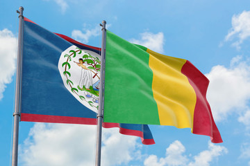Mali and Belize flags waving in the wind against white cloudy blue sky together. Diplomacy concept, international relations.