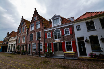 Fototapeta na wymiar Edam, the Netherlands, August 2019. The architecture of the Edam lodges is a characteristic example of the Netherlands. Red brick facade and red windows. Very fascinating.