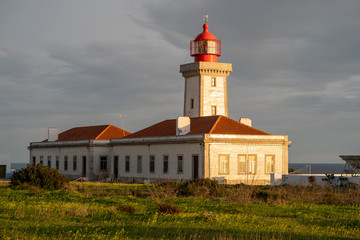 Fototapeta na wymiar Alfanzina Lighthouse, shot at dusk during the golden hour, with light shining on the building