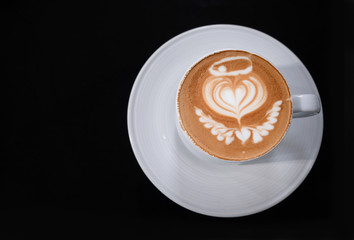 Coffee art with heart-shape pattern in cup on wooden table in the garden, Close up cup of coffee coffee with heart-shape pattern.Copy Space