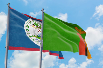 Zambia and Belize flags waving in the wind against white cloudy blue sky together. Diplomacy concept, international relations.