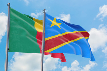 Congo and Benin flags waving in the wind against white cloudy blue sky together. Diplomacy concept, international relations.