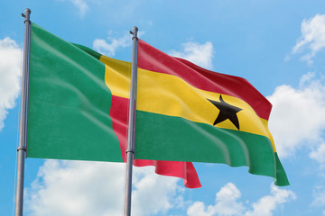 Ghana and Benin flags waving in the wind against white cloudy blue sky together. Diplomacy concept, international relations.