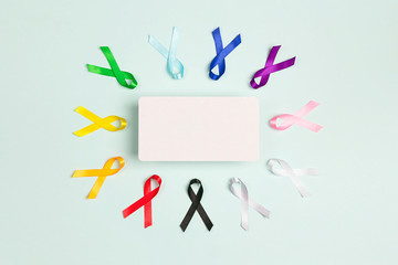 Colorful awareness ribbons with place for text on blue background. World cancer day concept,...