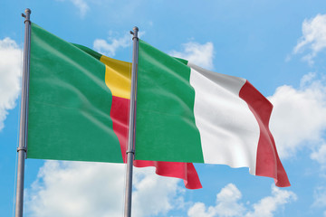 Italy and Benin flags waving in the wind against white cloudy blue sky together. Diplomacy concept, international relations.