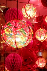Fototapeta premium In selective focus a row of beautiful Chinese lanterns hanging on a wire with red background 