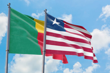 Liberia and Benin flags waving in the wind against white cloudy blue sky together. Diplomacy concept, international relations.