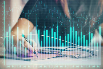 Multi exposure of woman's hands making notes with forex graph hologram. Concept of technical analysis.