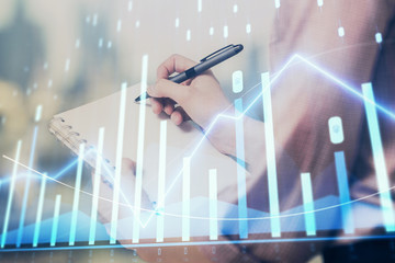 Multi exposure of hands making notes with forex chart huds. Stock market concept.