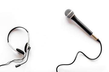 Television concept. Microphone and headset on white background top-down copy space