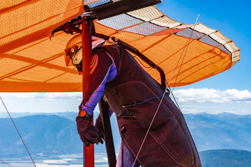 Man preparing to fly in a hang gliding. The professional pilot of hang-glider getting ready to fly...