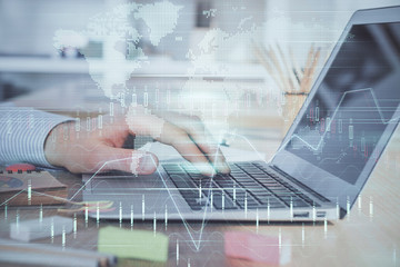 Double exposure of stock market graph with man working on laptop on background. Concept of financial analysis.