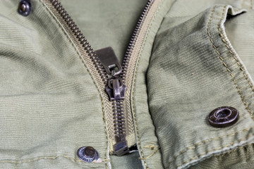 Fragment of outerwear with zipper and snap button fasteners closeup