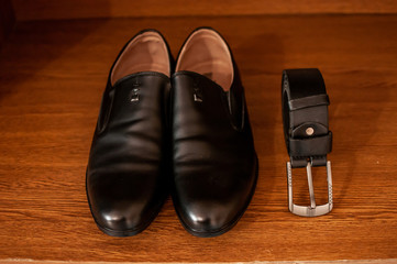 black belt and black shoes on the wooden table