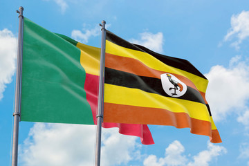 Uganda and Benin flags waving in the wind against white cloudy blue sky together. Diplomacy concept, international relations.