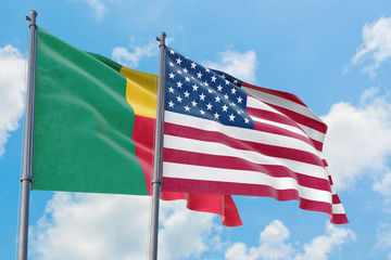 United States and Benin flags waving in the wind against white cloudy blue sky together. Diplomacy concept, international relations.
