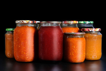 Pickled vegetables on a black background. Preservation in glass jars. Ingredients for canning...