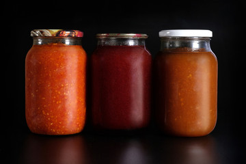 Pickled vegetables on a black background. Preservation in glass jars. Ingredients for canning vegetables.